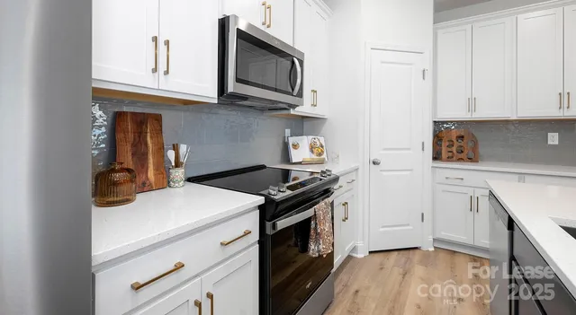 a kitchen with stainless steel appliances granite countertop a stove and a microwave