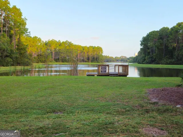 a view of a house next to a lake with a big yard