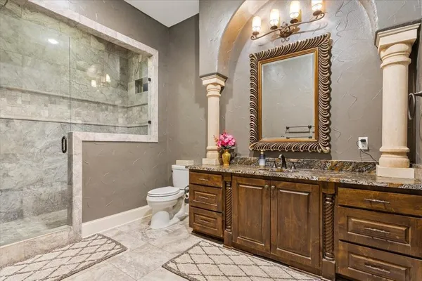 a bathroom with a granite countertop sink a toilet and a mirror