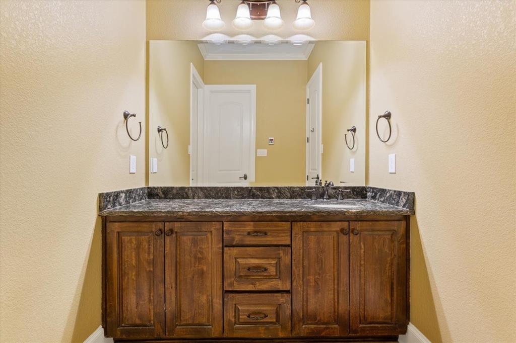 10020 Hidden Bluff Waco, TX 76657 - Photo 31 of 39 a bathroom with a granite countertop sink a mirror and a vanity