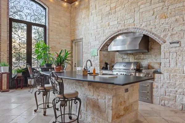 a kitchen with a stove a table and chairs in it