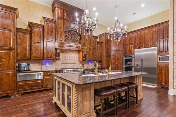 a kitchen with stainless steel appliances granite countertop a sink a stove and a refrigerator