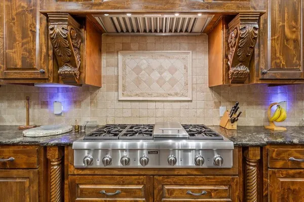 a kitchen with granite countertop a stove and cabinets