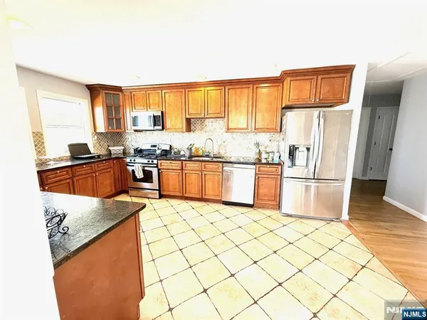 a kitchen with stainless steel appliances granite countertop a sink a stove and a refrigerator