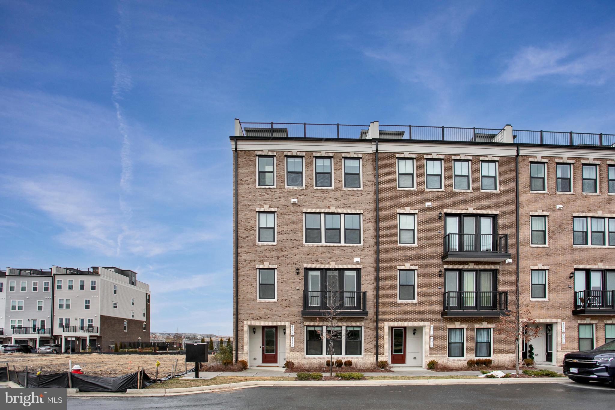 a front view of a building with lot of cars and trees