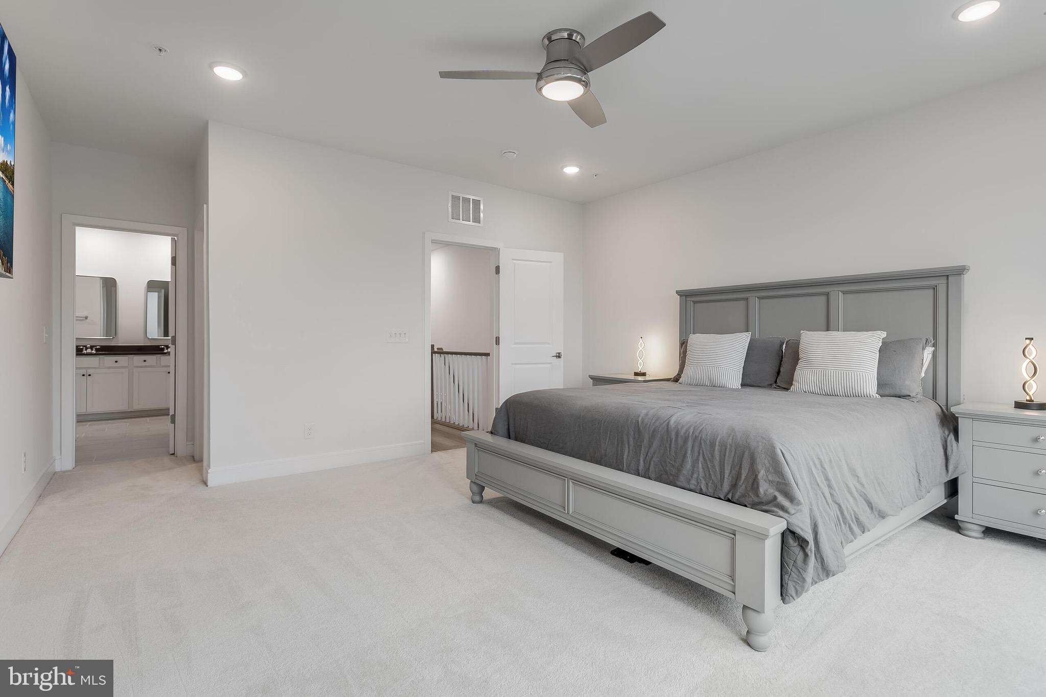 42708 Darala Drive Ashburn, VA 20147 - Photo 13 of 27 a spacious bedroom with a bed and a ceiling fan