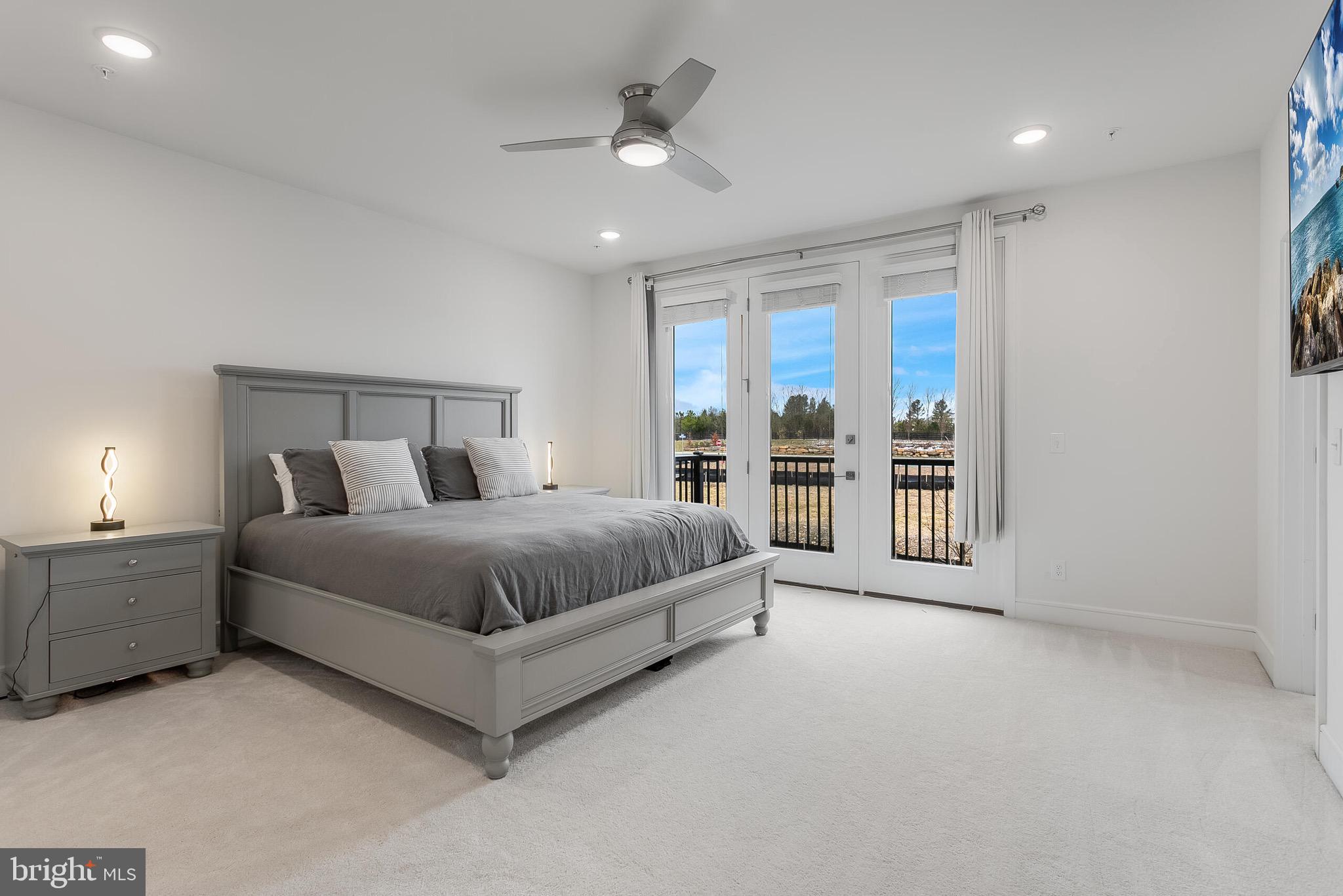 42708 Darala Drive Ashburn, VA 20147 - Photo 15 of 27 a spacious bedroom with a large bed and a chandelier fan