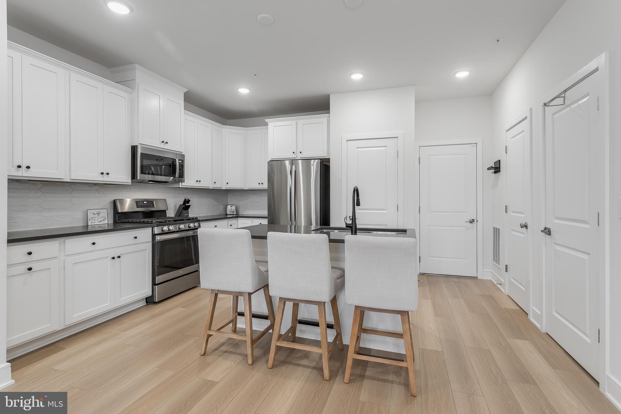 42708 Darala Drive Ashburn, VA 20147 - Photo 6 of 27 a kitchen with stainless steel appliances granite countertop a refrigerator a microwave a stove and white cabinets