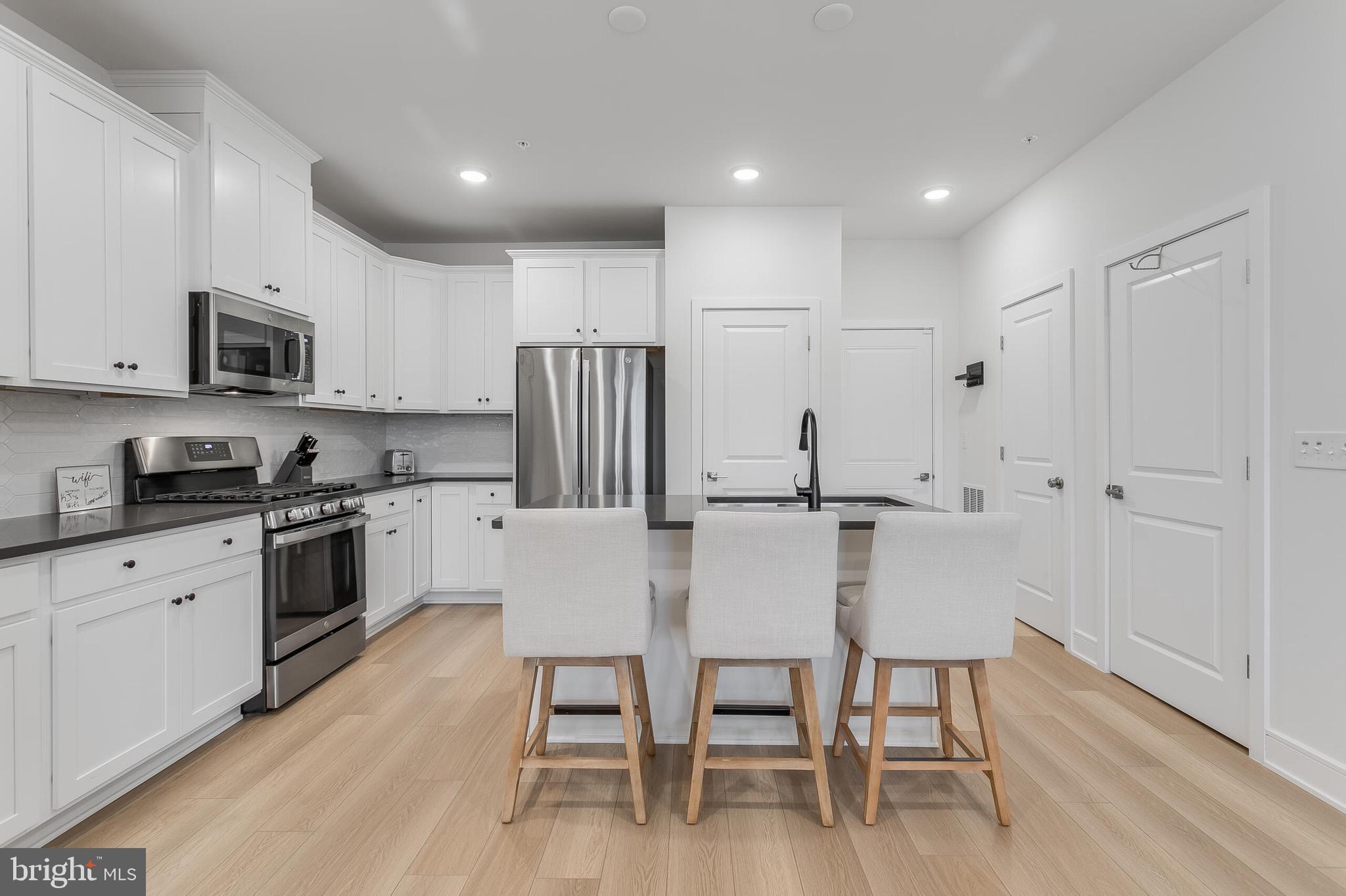 42708 Darala Drive Ashburn, VA 20147 - Photo 10 of 27 a kitchen with stainless steel appliances a white table and chairs in it