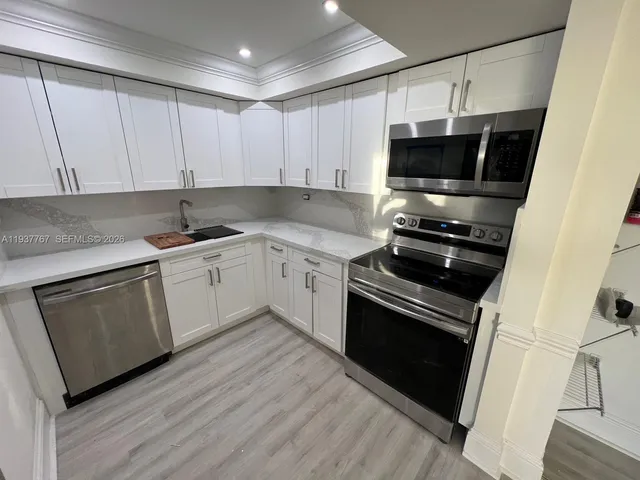 a kitchen with a sink appliances and cabinets