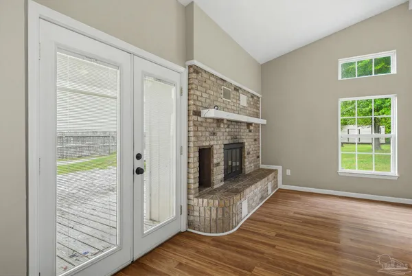 a view of a hallway with wooden floor and a fireplace
