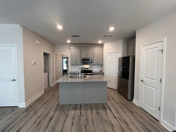 a kitchen with a refrigerator and a stove top oven