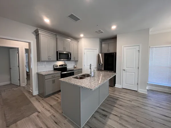 a kitchen with granite countertop a sink stove and refrigerator