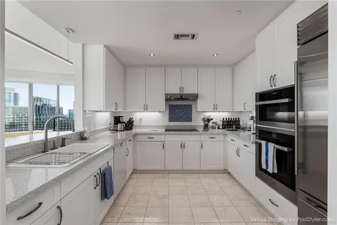 a kitchen with stainless steel appliances granite countertop a sink dishwasher stove and refrigerator