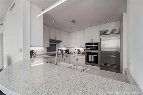 a kitchen with stainless steel appliances granite countertop a refrigerator sink and stove