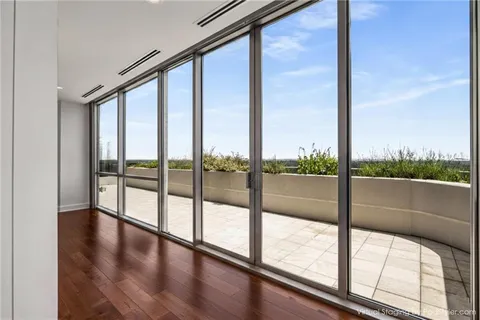 a view of an empty room with wooden floor and iron stairs