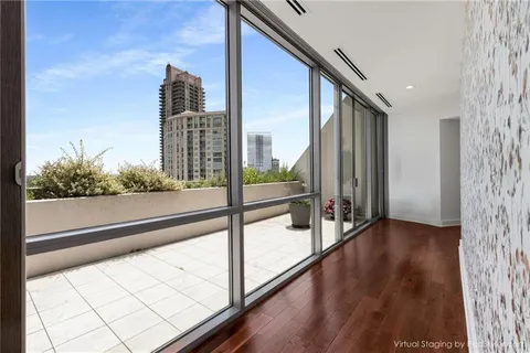 a view of a balcony with floor to ceiling windows and wooden floor