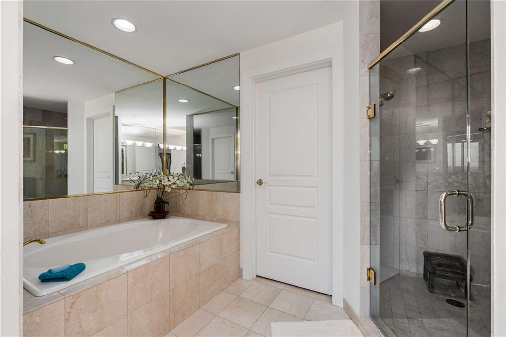 700 Park Regency Place Northeast, Unit 2201 Atlanta, GA 30326 - Photo 24 of 47 a spacious bathroom with a tub shower and mirror