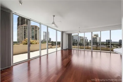 a view of empty room with wooden floor and floor to ceiling window
