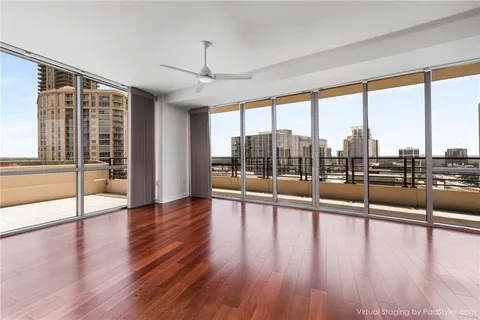 a view of an empty room with wooden floor and windows