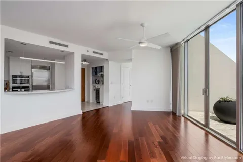 a view of a big room with wooden floor and windows