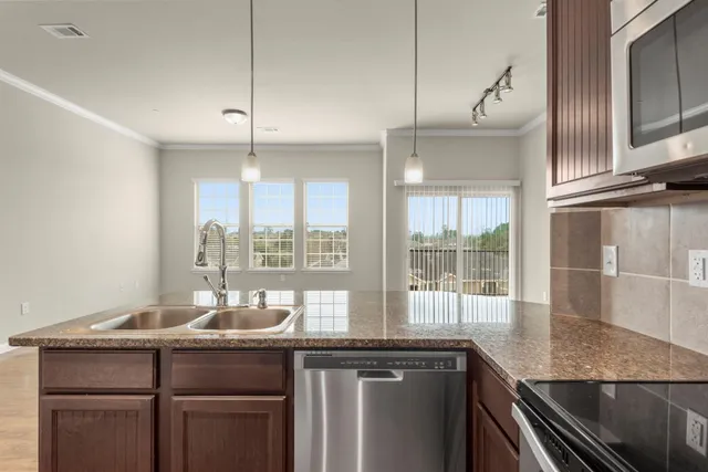 a kitchen with granite countertop a sink and white cabinets