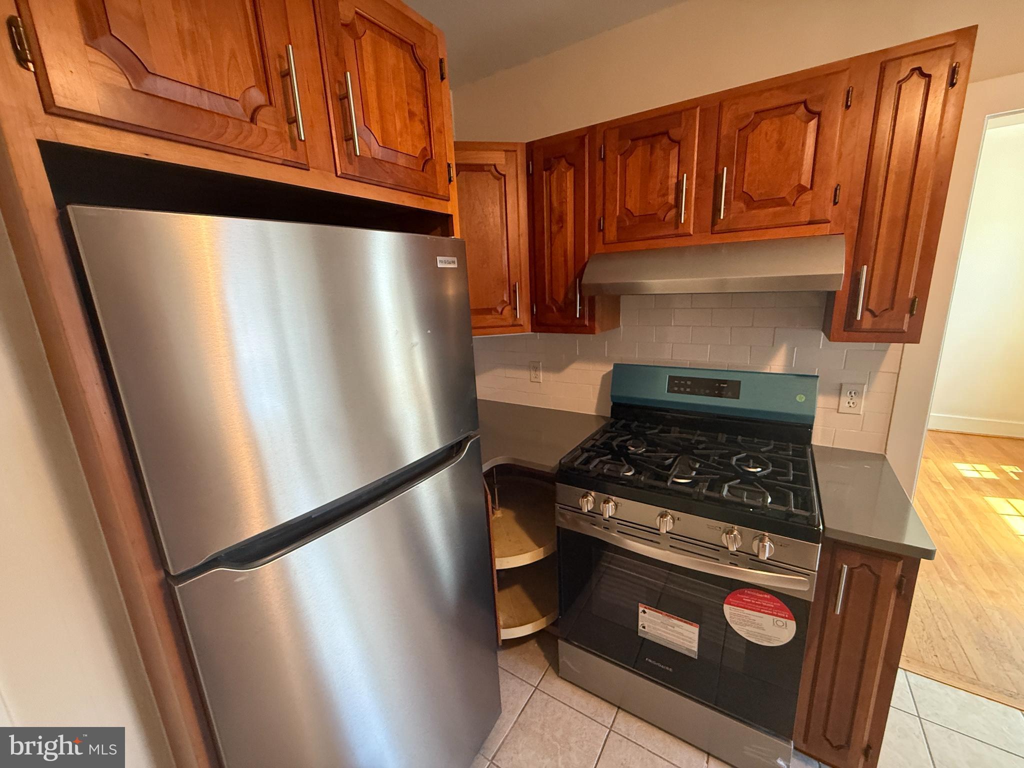 714 Wayne Avenue West Reading, PA 19611 - Photo 6 of 16 a kitchen with wooden cabinets and a stove top oven