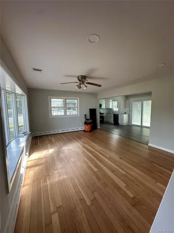 wooden floor in an empty room with a window