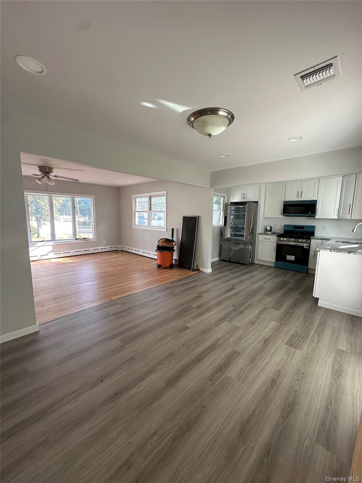 16 Blythe Road Ronkonkoma, NY 11779 - Photo 3 of 11 a view of a living room a kitchen with furniture and wooden floor