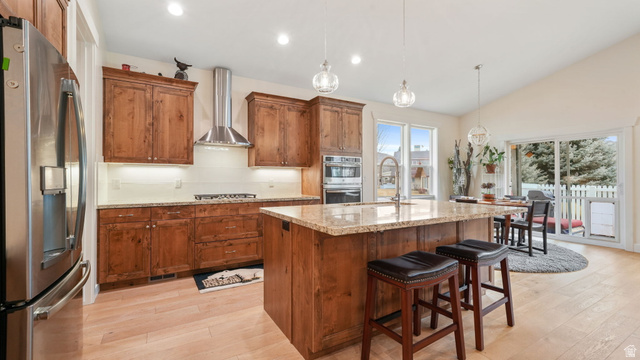1238 Canyon View Road Midway, UT 84049 - Photo 7 of 36 Open-concept kitchen featuring wood-finish cabinetry, stainless steel appliances, and a central island with a stone countertop