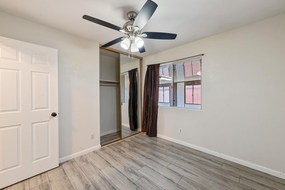 22 Sharon Drive Bay Point, CA 94565 - Photo 22 of 33 an empty room with wooden floor chandelier fan and windows