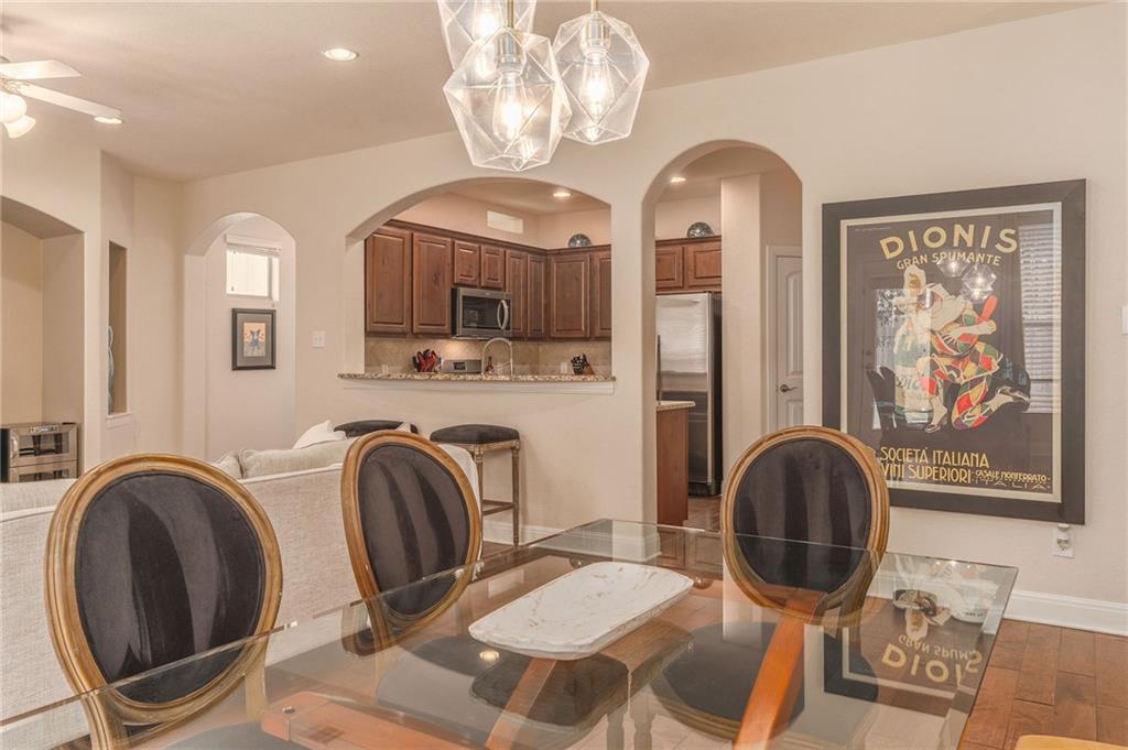 6708 Menchaca Road, Unit 14 Austin, TX 78745 - Photo 14 of 22 Dining area featuring wood-finish flooring and a contemporary geometric chandelier