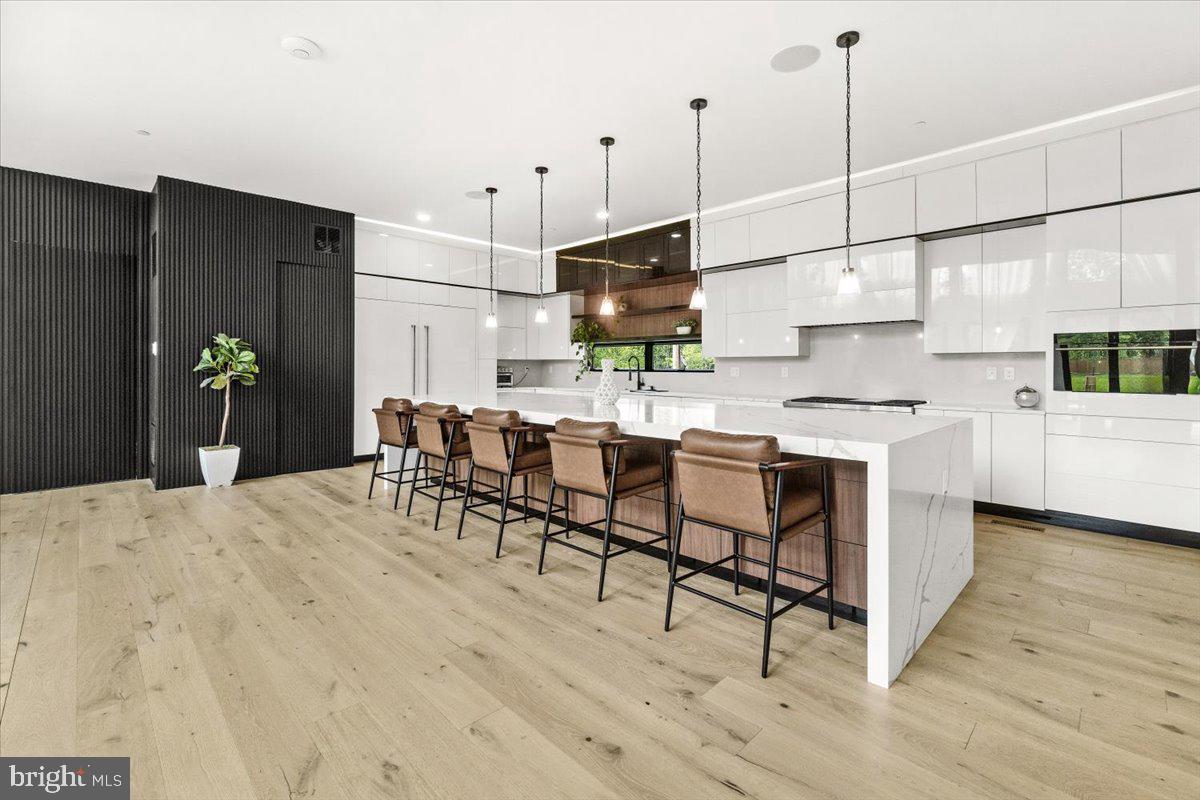 15807 Thompson Road Silver Spring, MD 20905 - Photo 19 of 82 a kitchen with stainless steel appliances kitchen island granite countertop a sink cabinets and wooden floor