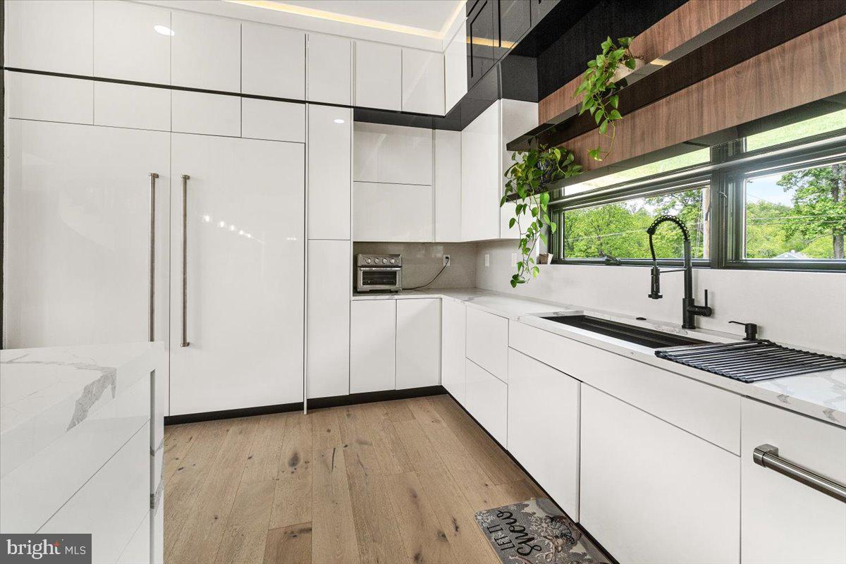 15807 Thompson Road Silver Spring, MD 20905 - Photo 20 of 82 a kitchen with granite countertop white cabinets and white appliances
