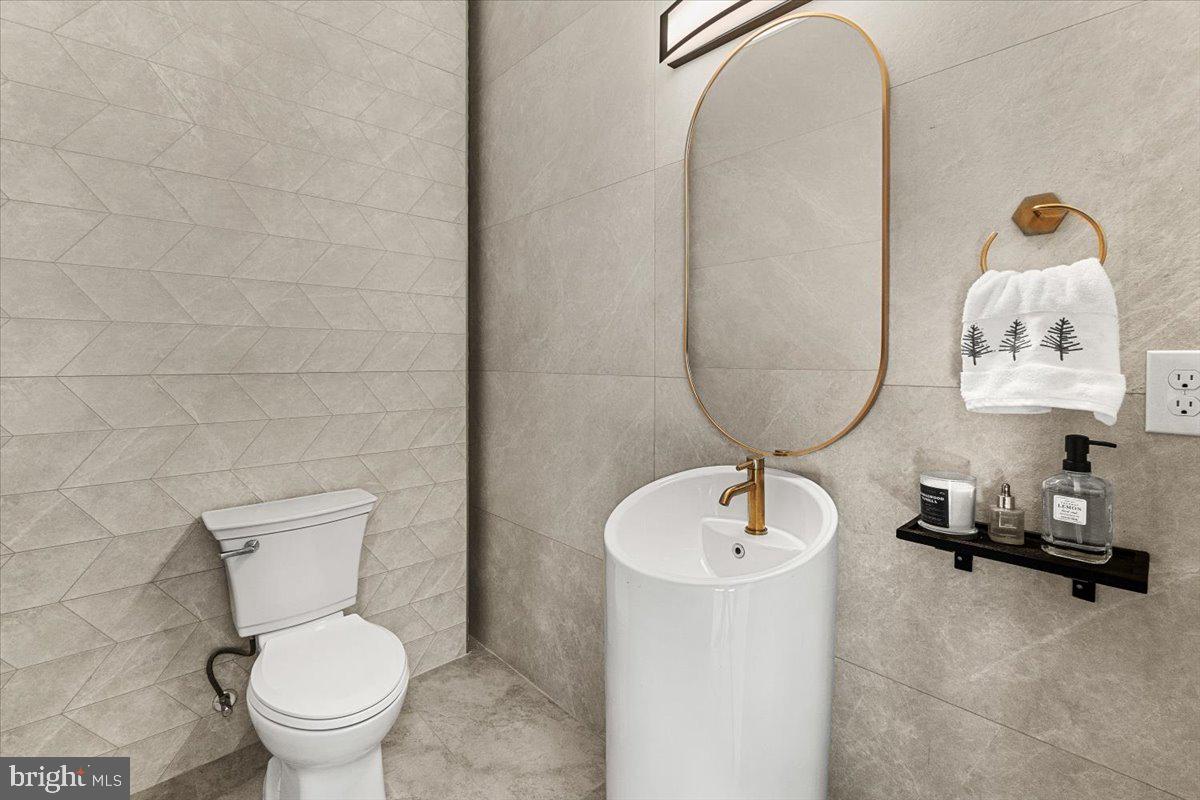 15807 Thompson Road Silver Spring, MD 20905 - Photo 24 of 82 a bathroom with a toilet sink and mirror