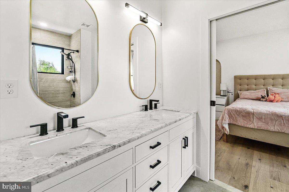 15807 Thompson Road Silver Spring, MD 20905 - Photo 39 of 82 a en suite bathroom with double vanity sinks and a mirror