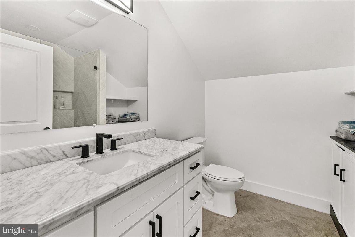 15807 Thompson Road Silver Spring, MD 20905 - Photo 51 of 82 a bathroom with a granite countertop sink a toilet and a mirror