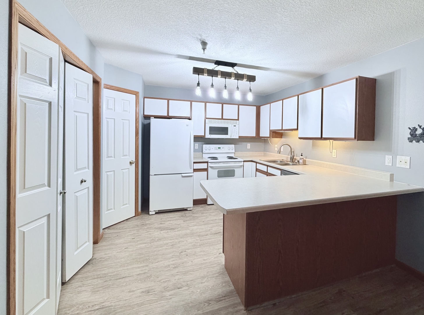 213 East Price Street, Unit 202 Eldridge, IA 52748 - Photo 11 of 20 a kitchen with kitchen island a sink stainless steel appliances cabinets and a window