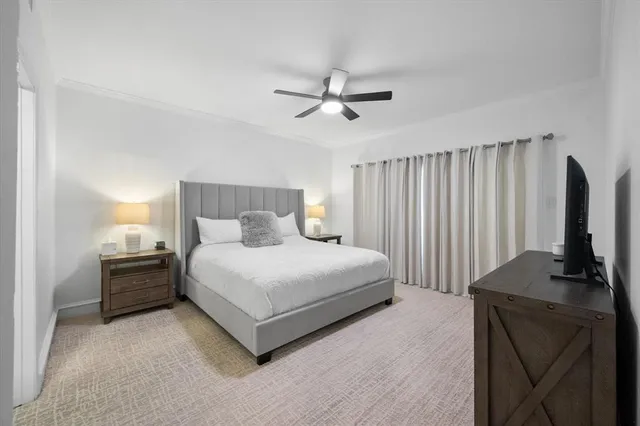 a bedroom with a bed flat screen tv and a ceiling fan