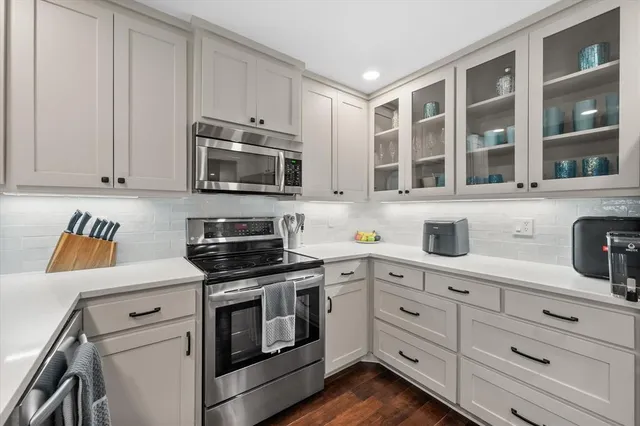 a kitchen with granite countertop white cabinets stainless steel appliances and a sink