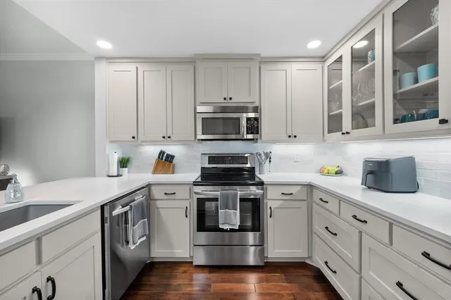 a kitchen with cabinets stainless steel appliances and a sink
