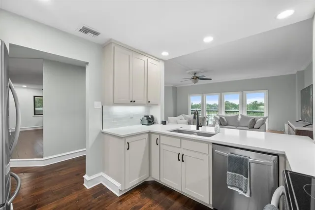 a kitchen with a sink cabinets and wooden floor
