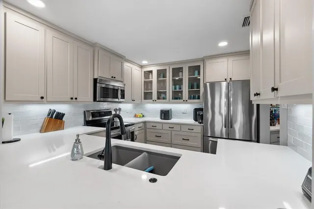 a kitchen with stainless steel appliances a refrigerator sink microwave and cabinets