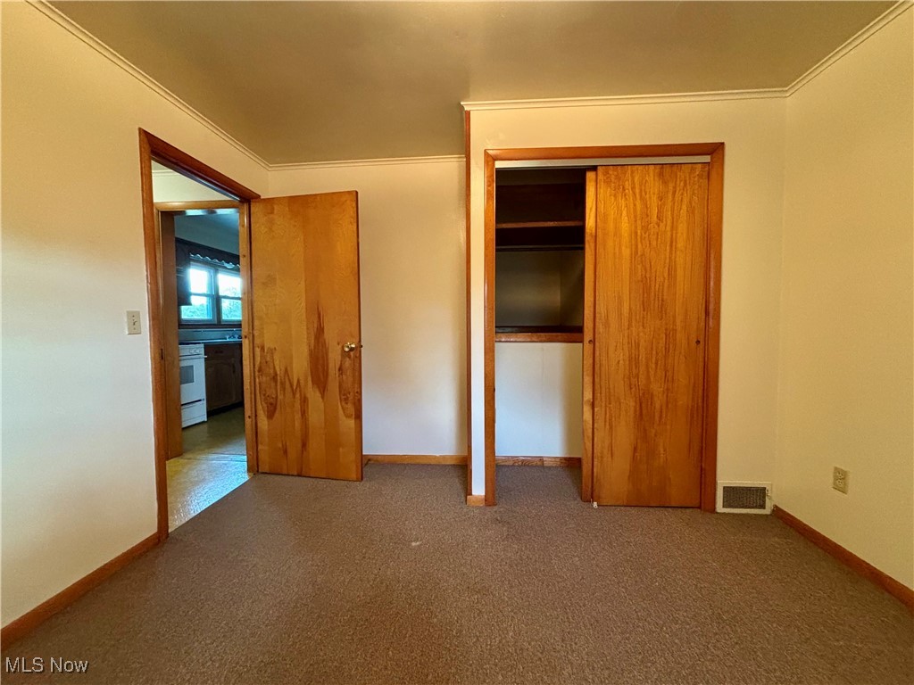 164 Locust Lane Follansbee, WV 26037 - Photo 10 of 19 Unfurnished bedroom with dark carpet, crown molding, and a closet
