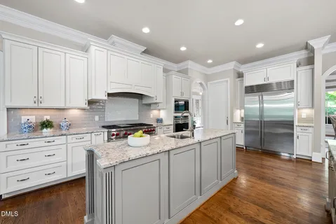 a kitchen with a sink a counter space appliances and cabinets