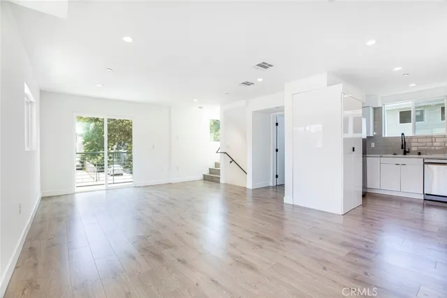 a view of a kitchen with wooden floor and a window