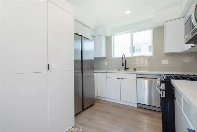 a kitchen with white cabinets and white appliances