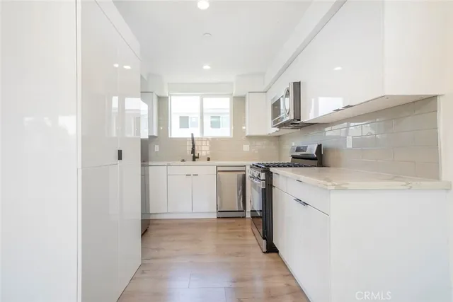 a kitchen with a sink a stove cabinets and a refrigerator