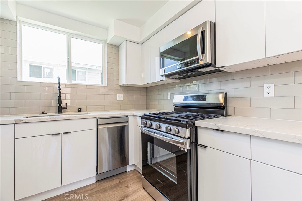 1843 West 20th Street Los Angeles, CA 90007 - Photo 20 of 38 a kitchen with cabinets stainless steel appliances a sink and a stove