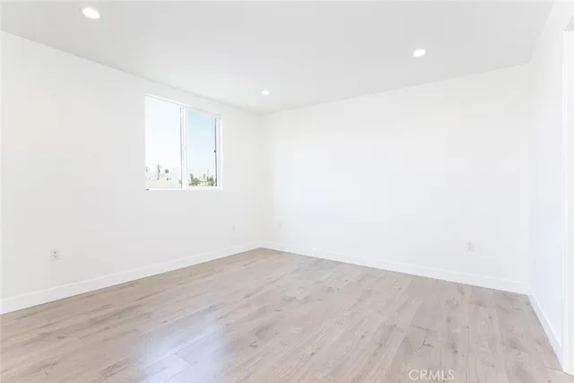 an empty room with wooden floor and a window